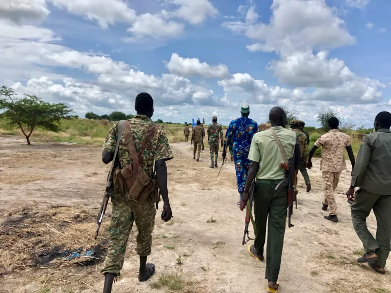 Armed personnel walking in a rural area in South Sudan