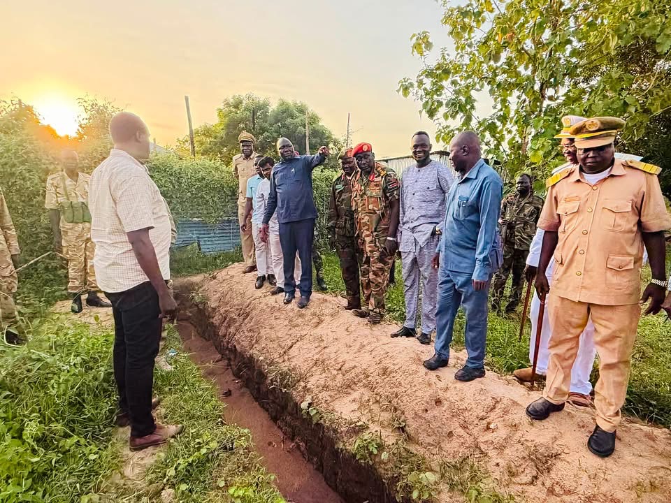 Officials inspecting an unfinished perimeter fence
